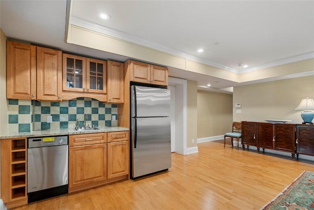 kitchen featuring appliances with stainless steel finishes, sink, crown molding, light stone countertops, and light hardwood / wood-style flooring