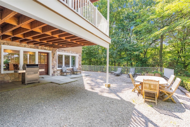 view of patio featuring a balcony and a grill