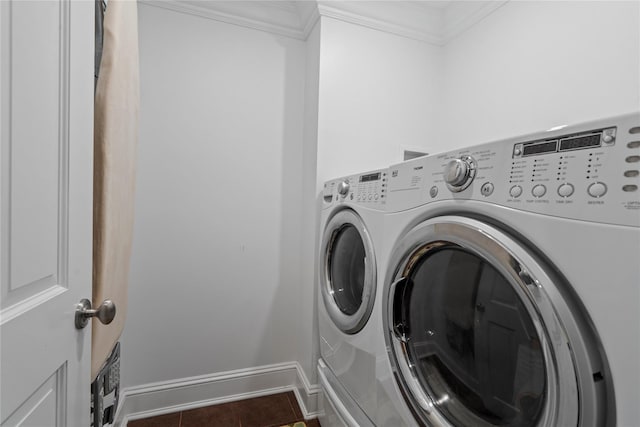 clothes washing area featuring crown molding, dark tile patterned floors, and washing machine and clothes dryer