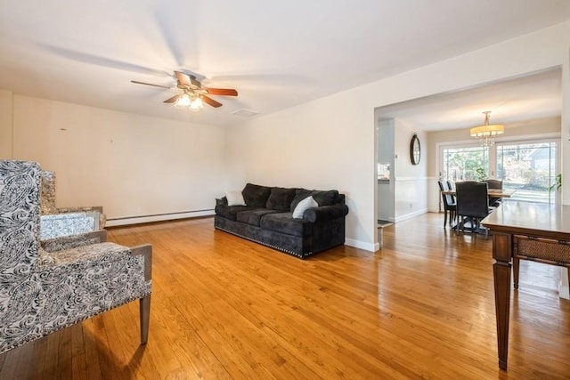 living room featuring hardwood / wood-style flooring, ceiling fan, and baseboard heating