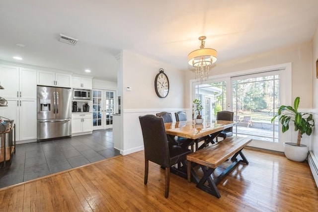 dining space with a chandelier, dark wood-type flooring, and a baseboard radiator