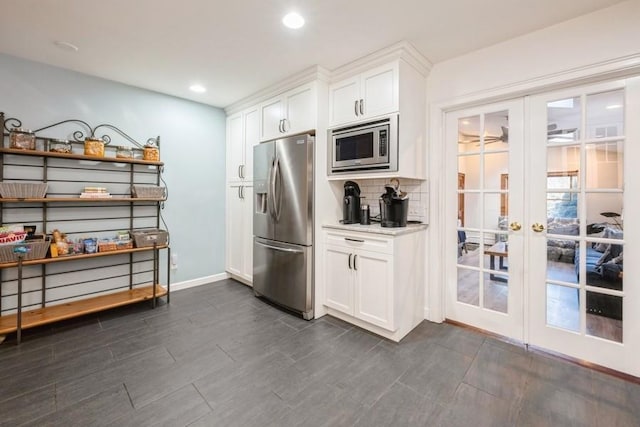 kitchen with backsplash, white cabinetry, french doors, and appliances with stainless steel finishes