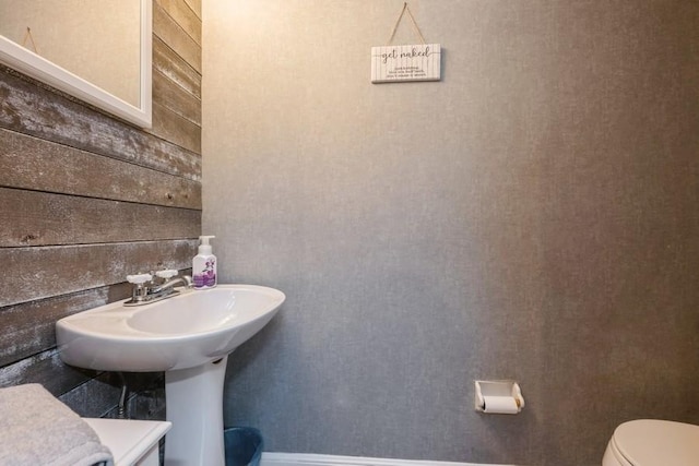 bathroom with wooden walls and toilet