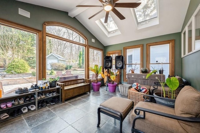 sunroom with ceiling fan and vaulted ceiling with skylight