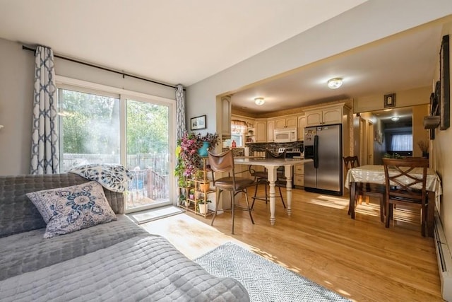 bedroom featuring access to outside, stainless steel refrigerator with ice dispenser, and light wood-type flooring