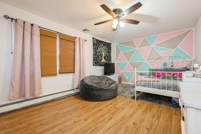 bedroom with hardwood / wood-style flooring, baseboard heating, and ceiling fan