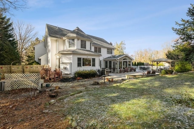 rear view of house with a gazebo, a lawn, and a patio