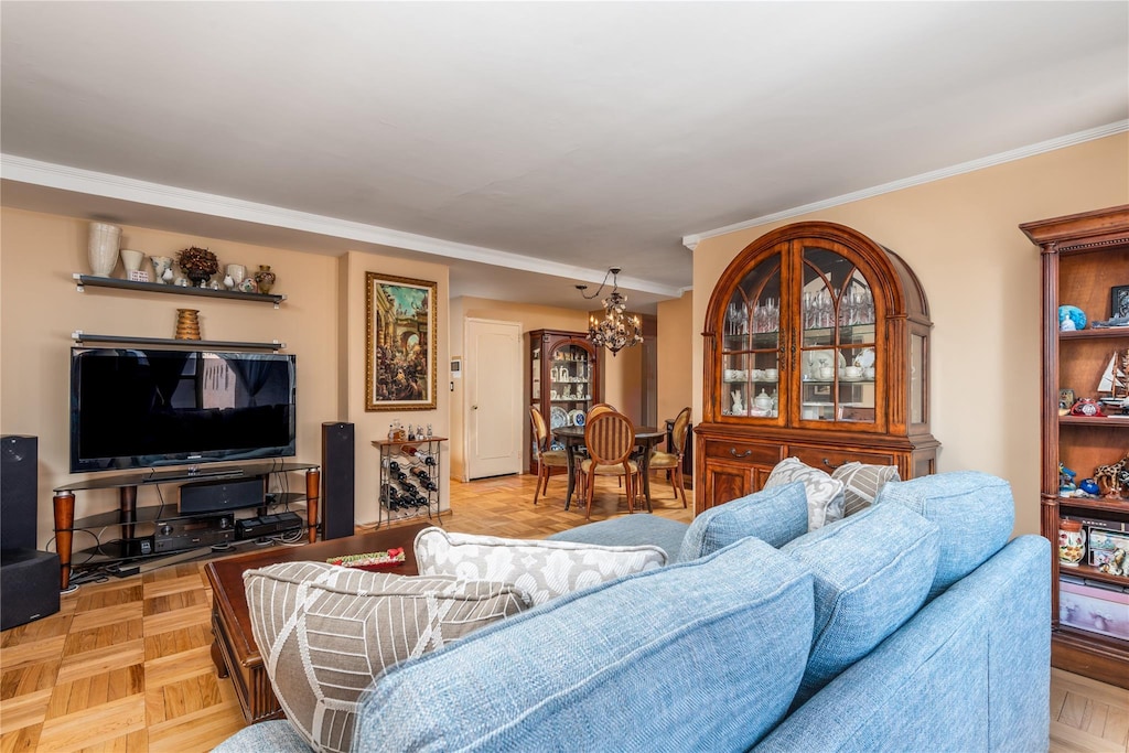 living room with ornamental molding, a chandelier, and light parquet floors