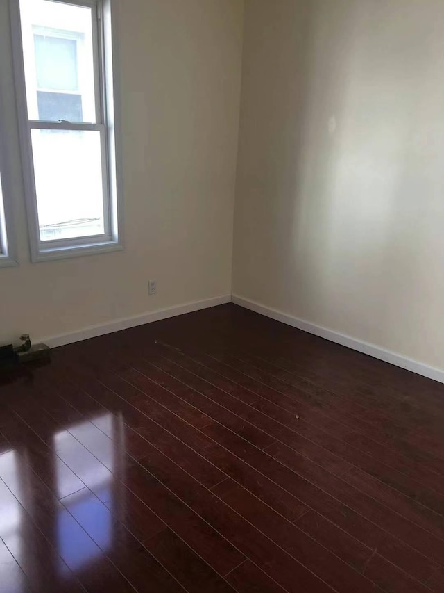 spare room with dark hardwood / wood-style flooring