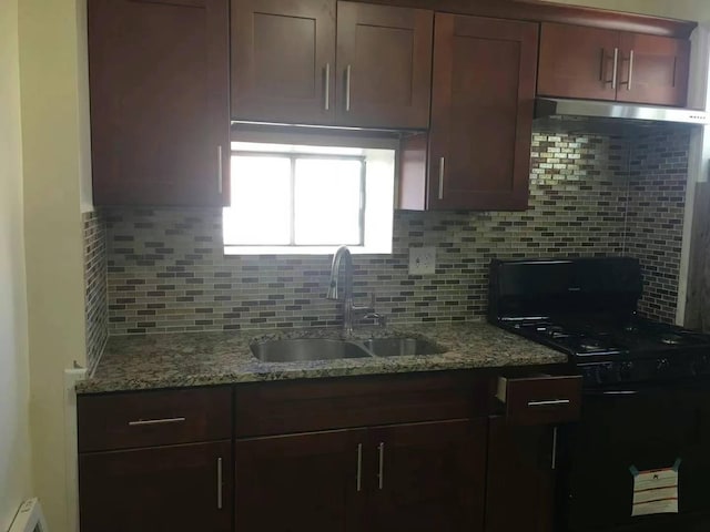 kitchen with decorative backsplash, light stone countertops, and sink