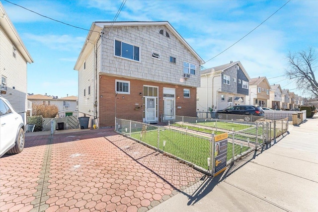 view of front facade featuring a front yard, a gate, fence, and a residential view