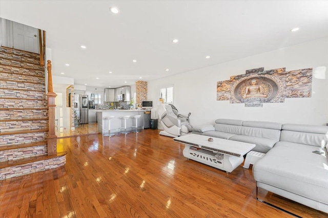 unfurnished living room with light wood-type flooring, stairway, and recessed lighting