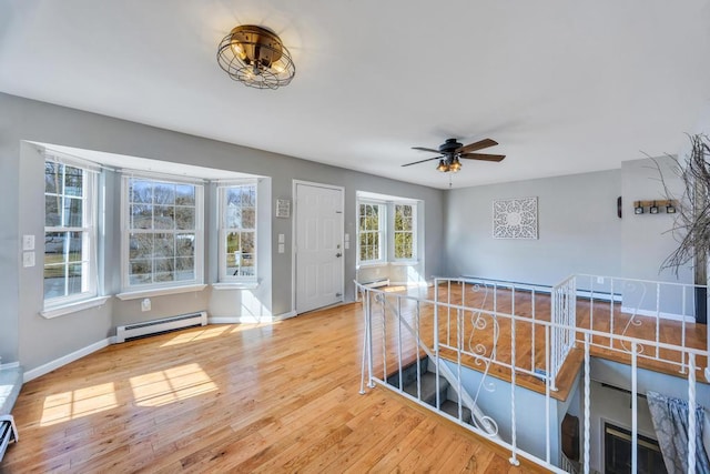 entrance foyer featuring a baseboard radiator, baseboards, baseboard heating, and wood finished floors