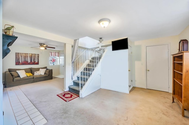 unfurnished living room featuring light carpet, ceiling fan, and stairs