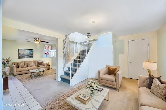 living room with stairs, a ceiling fan, and light tile patterned flooring