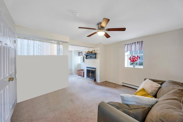 living room with light carpet, ceiling fan, baseboard heating, and a glass covered fireplace