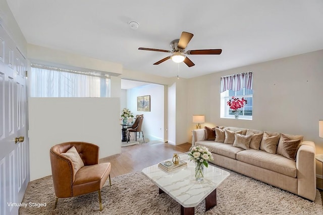 living area featuring light wood-type flooring and a ceiling fan