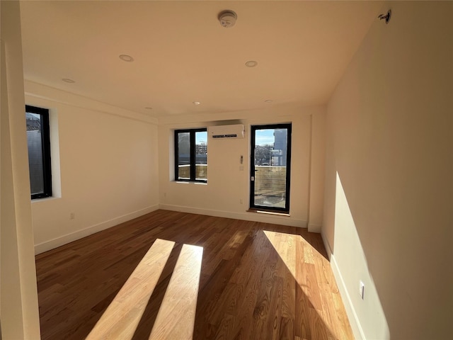 empty room featuring dark hardwood / wood-style flooring and a wall unit AC