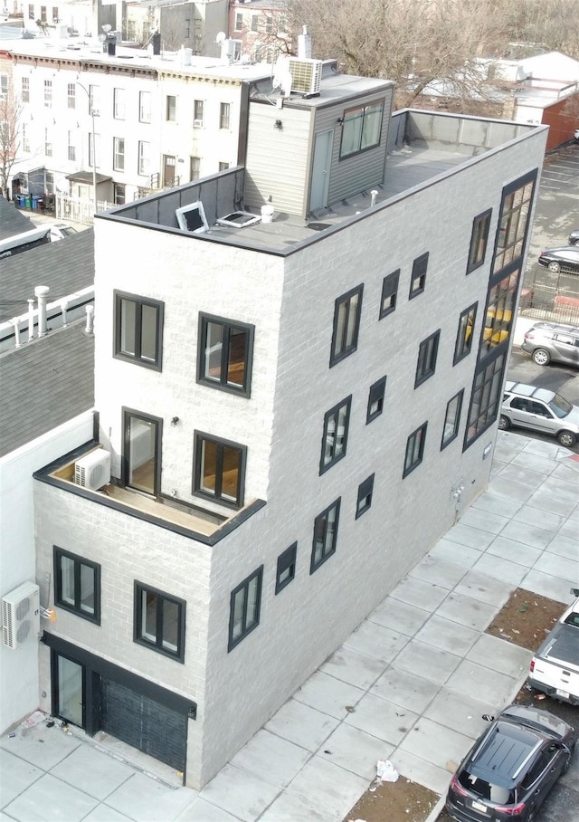 view of building exterior featuring cooling unit and a wall mounted air conditioner