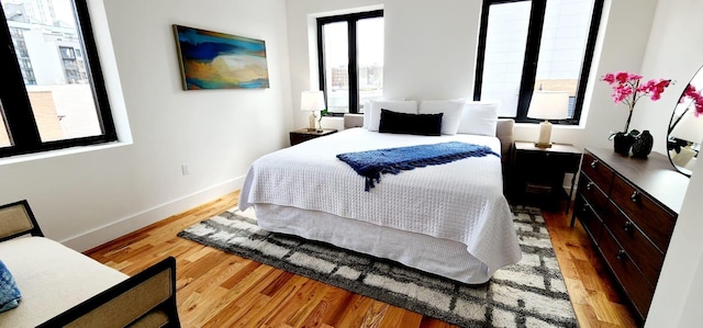 bedroom with light wood-style floors and baseboards