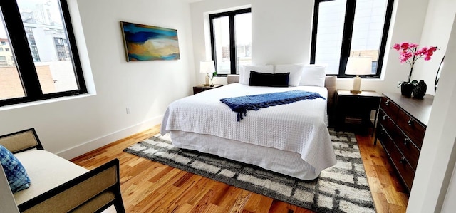 bedroom with light wood-type flooring and baseboards