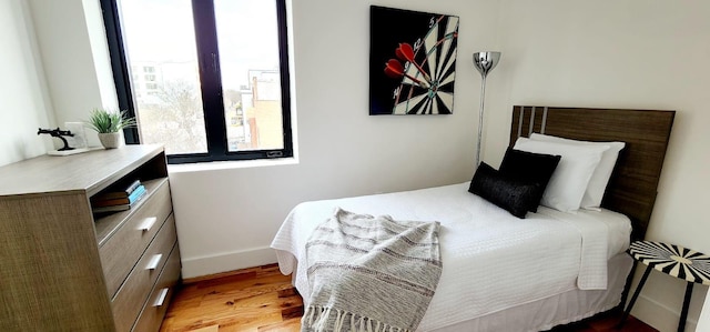 bedroom with baseboards and wood finished floors