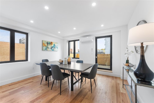 dining area featuring an AC wall unit, recessed lighting, light wood-style floors, and baseboards