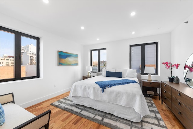 bedroom featuring light wood-type flooring, recessed lighting, and baseboards