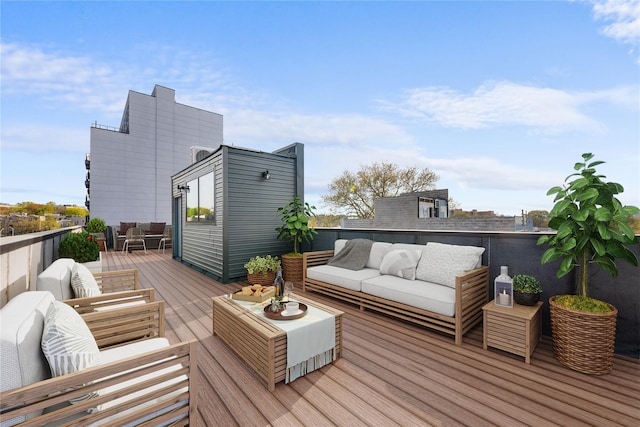 wooden terrace with an outdoor living space