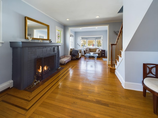 interior space featuring a fireplace, wood-type flooring, and a baseboard radiator