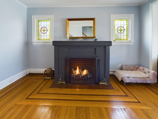 interior details featuring a brick fireplace, ornamental molding, and a baseboard heating unit