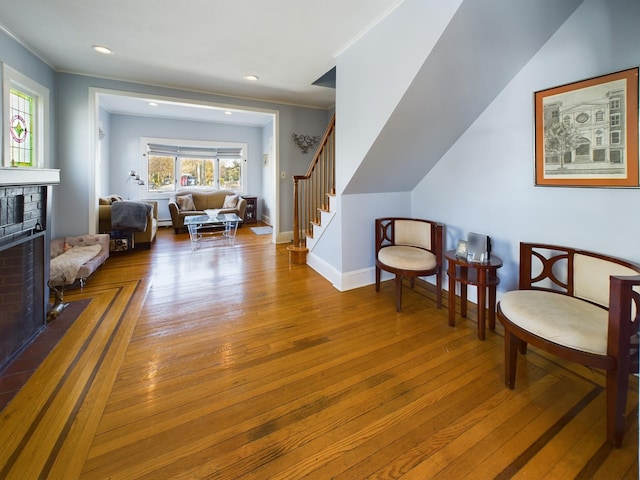 living area with hardwood / wood-style floors and a brick fireplace