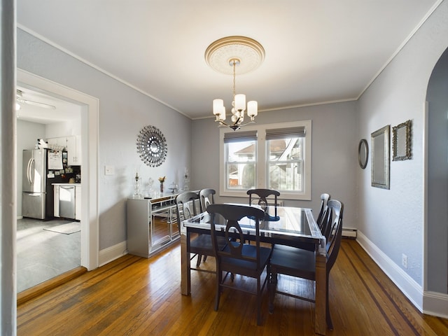 dining room with ceiling fan with notable chandelier, a baseboard radiator, dark hardwood / wood-style floors, and ornamental molding