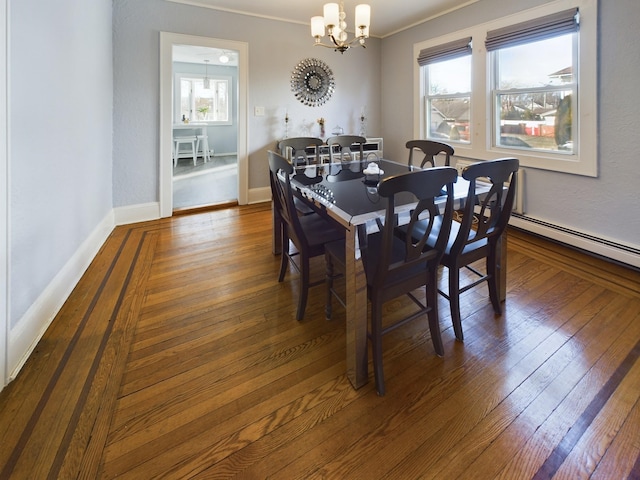 dining room with a healthy amount of sunlight, dark wood-type flooring, crown molding, and a chandelier