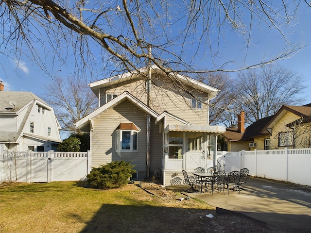 rear view of property with a lawn and a patio