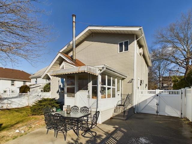 back of house featuring a patio area and a sunroom