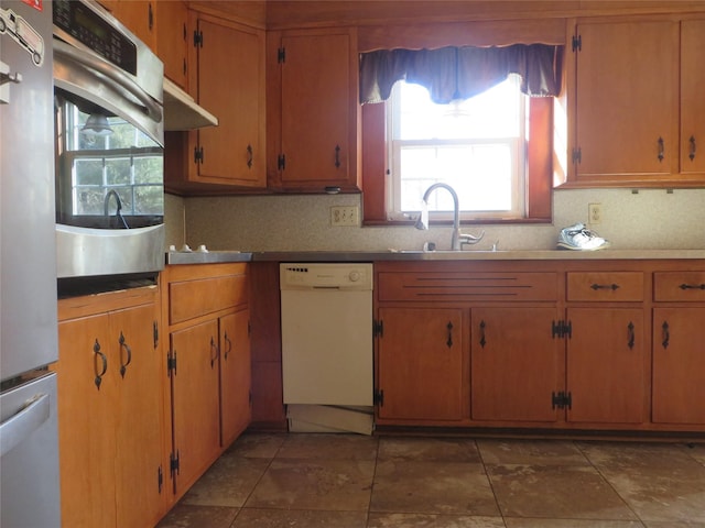 kitchen with appliances with stainless steel finishes, tasteful backsplash, and sink