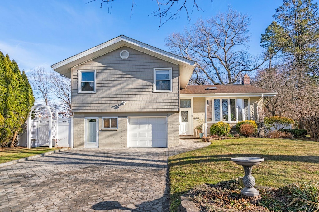 split level home featuring a garage and a front yard