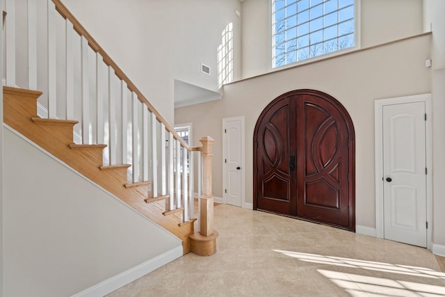 tiled entryway with a towering ceiling