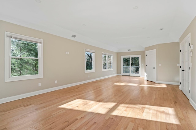 spare room featuring light hardwood / wood-style floors and a healthy amount of sunlight