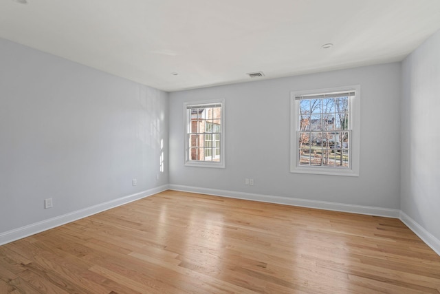 unfurnished room with a wealth of natural light and light hardwood / wood-style flooring