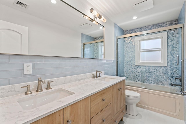 full bathroom with tile patterned floors, combined bath / shower with glass door, vanity, and toilet