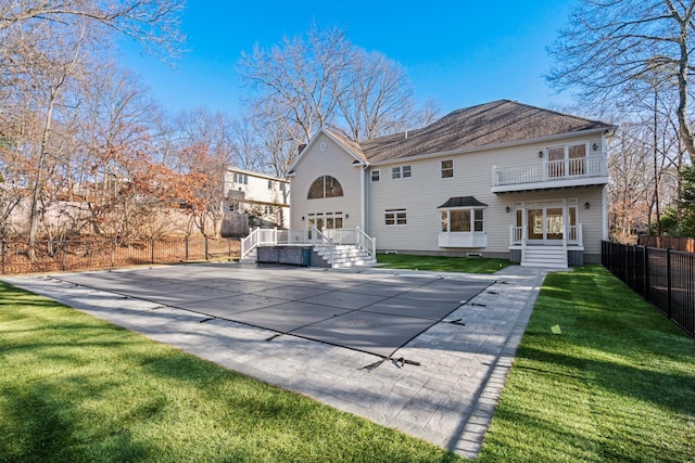 back of house with a wooden deck, a balcony, and a yard