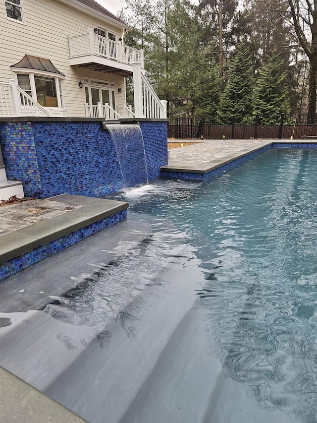 view of swimming pool with a patio area, french doors, and pool water feature