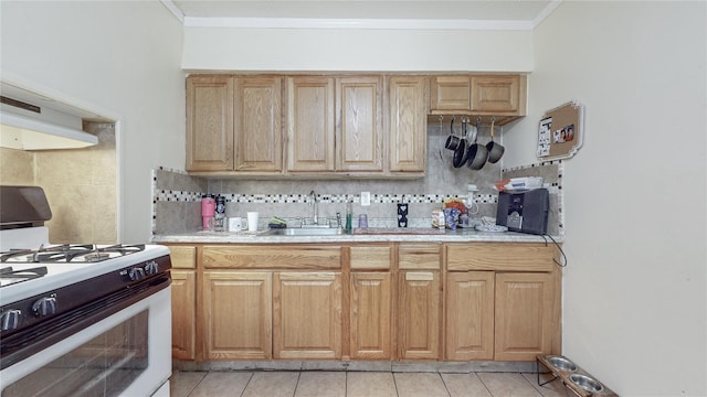 kitchen with backsplash, gas range gas stove, sink, and light tile patterned floors