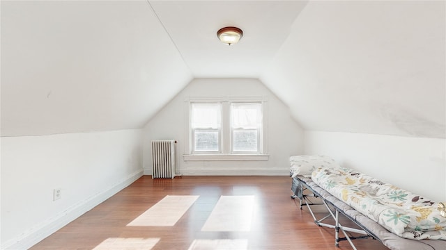 additional living space featuring radiator, wood-type flooring, and lofted ceiling