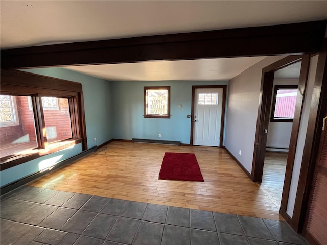 entrance foyer with beamed ceiling, a wealth of natural light, and hardwood / wood-style floors