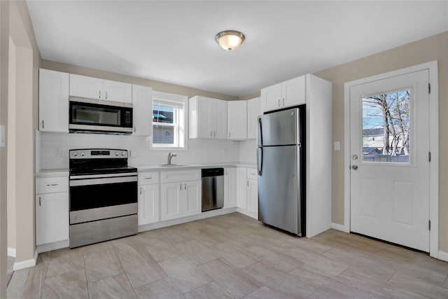 kitchen with backsplash, white cabinetry, sink, and appliances with stainless steel finishes