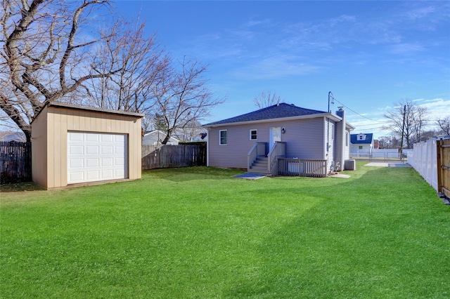 back of property featuring a lawn, cooling unit, a garage, and an outdoor structure