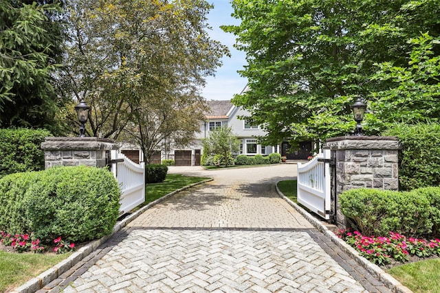 exterior space featuring decorative driveway and a gate